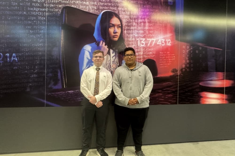 two students stand next to each other 