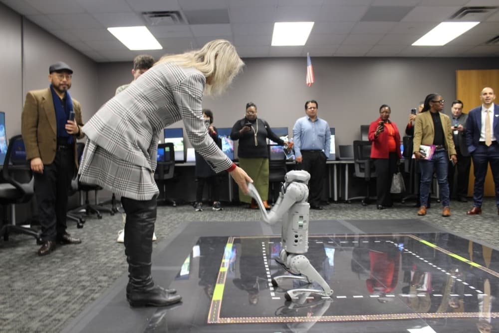 An instructor shaking the hand of a robot