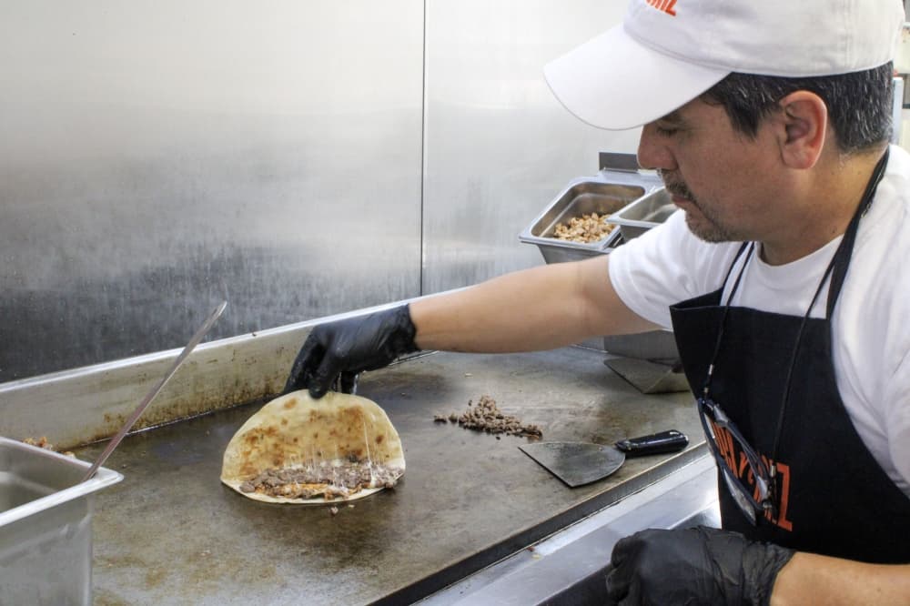 An image of one of the family members cooking at the restaurant. 