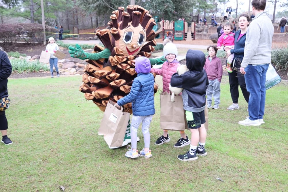 kids greeting pinecone mascot