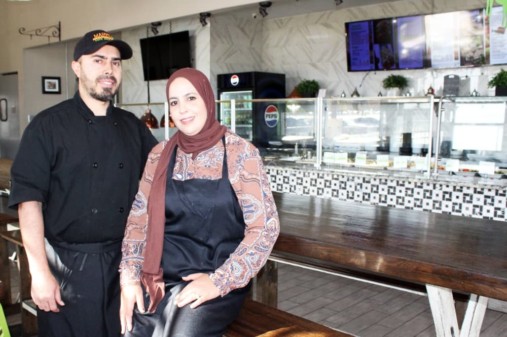 Male and female standing next to each other in a restaurant. 