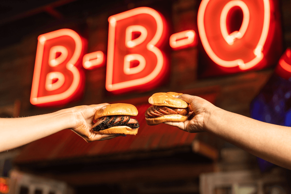 People holding barbecue sandwiches 