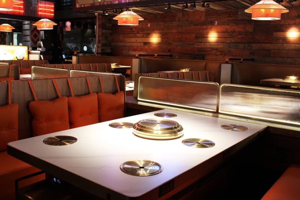 Tables in a restaurant featuring hot pot capabilities. 