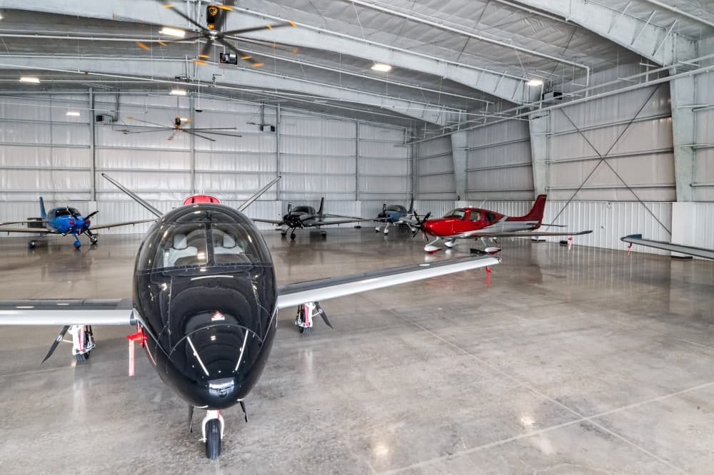 Image of a hangar with Cirrus planes parked inside.
