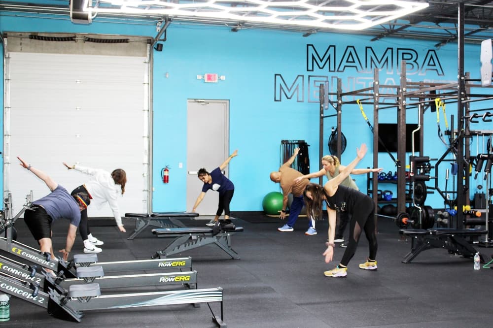 Group of women and men working out in a circle in a gym. 