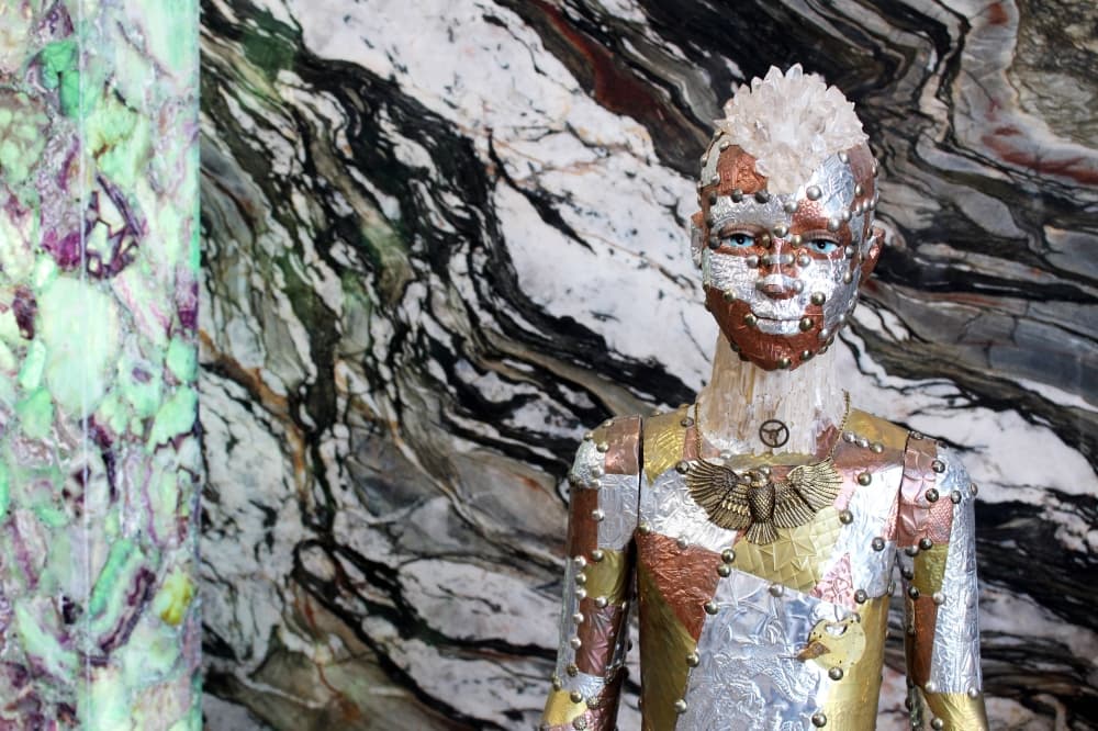 Sculpture of a person made with stone and various metals. 