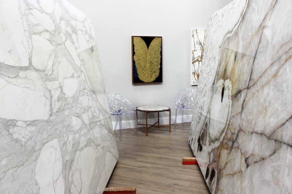 White stone slabs featuring shades of gray veins displayed in a showroom. 