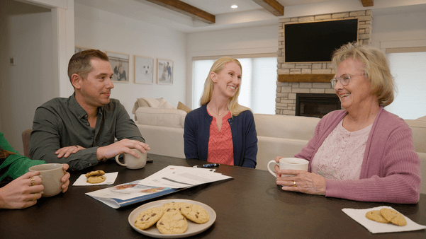 Family visiting elderly parent during the holidays while discussing in-home senior care services in Prosper, Texas