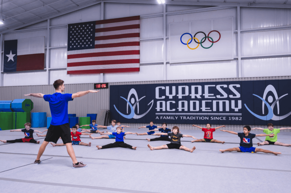 Coach leading gymnastics stretch class