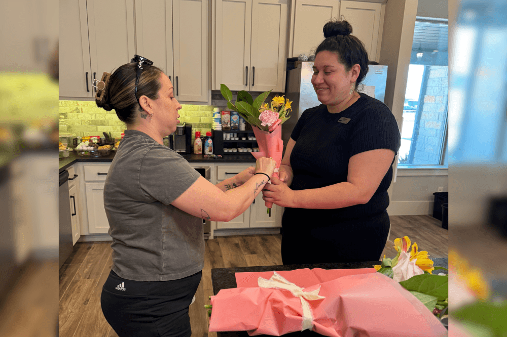 Resident hands another resident flowers