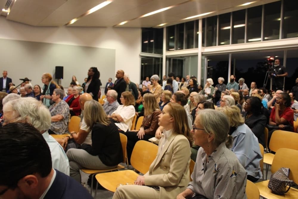 People sitting in chairs for a town hall meeting