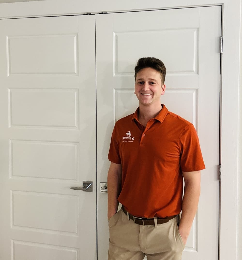 man in red standing against white door