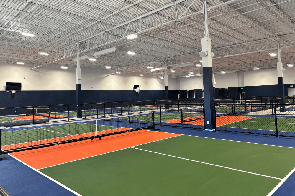 Dill Dinkers Plano indoor pickleball facility with 10 professional courts, spacious lounge areas, climate-controlled environment, and dedicated spaces for tournaments, community events, and socializing in Plano, Texas.
