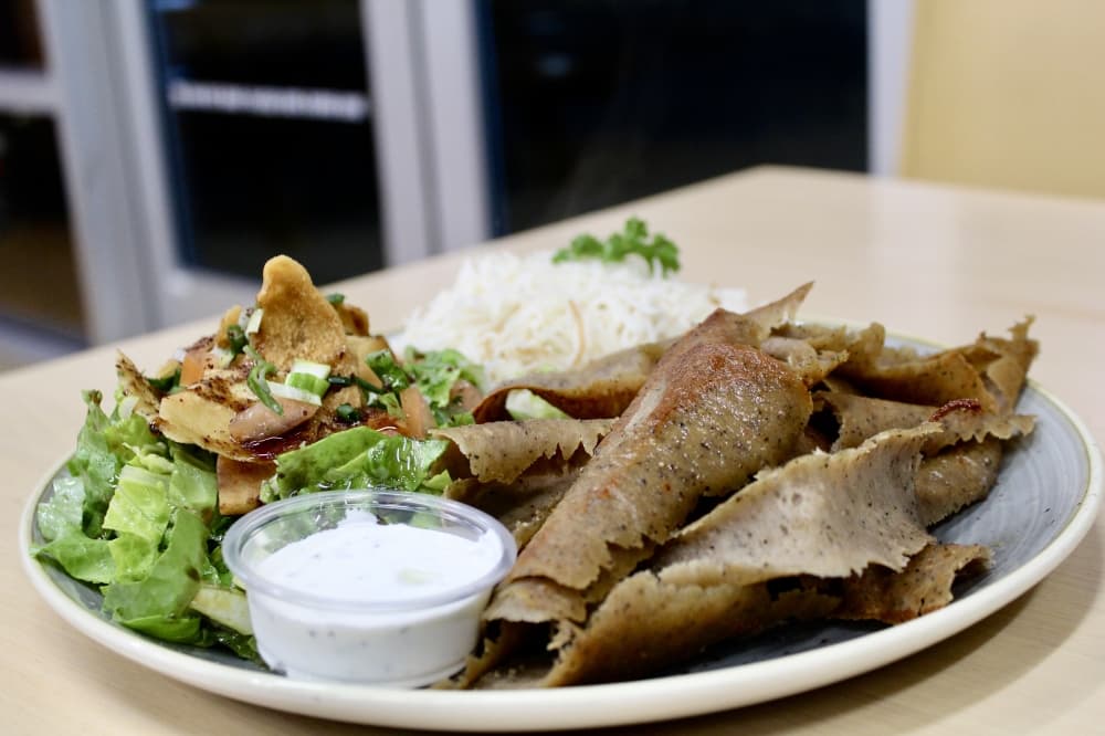 The gyro plate ($16.99) includes sliced gyro meat served with Mediterranean rice, Nadia's salad, tzatziki and pita. (Jovanna Aguilar/Community Impact)