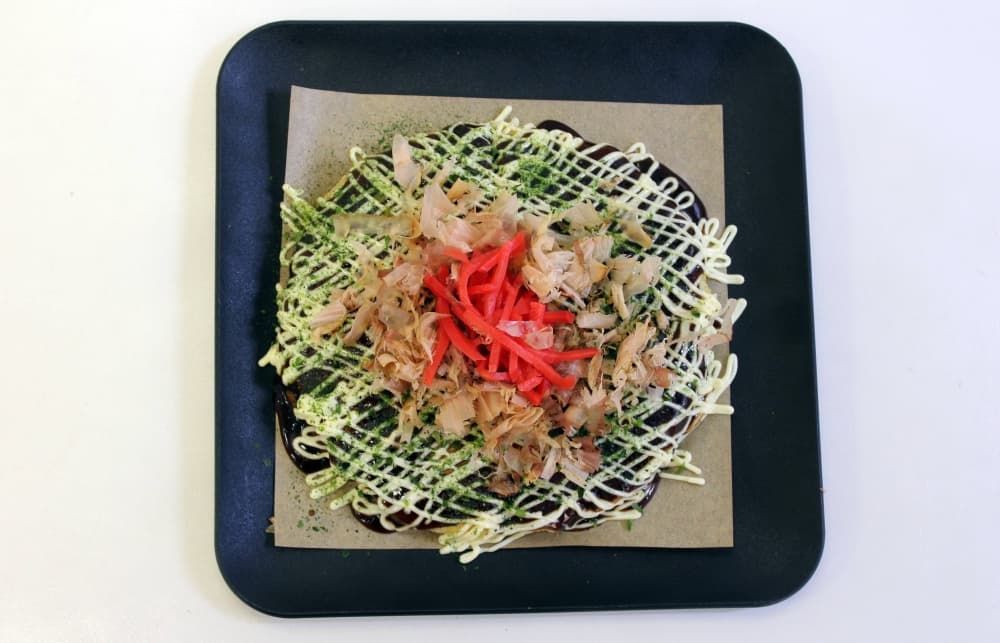 An overview of a circular dish featuring a variety of sauces crisscrossed across the top. 