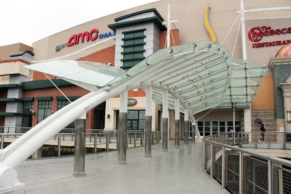 Exterior of a mall entry featuring arched covered entry. 