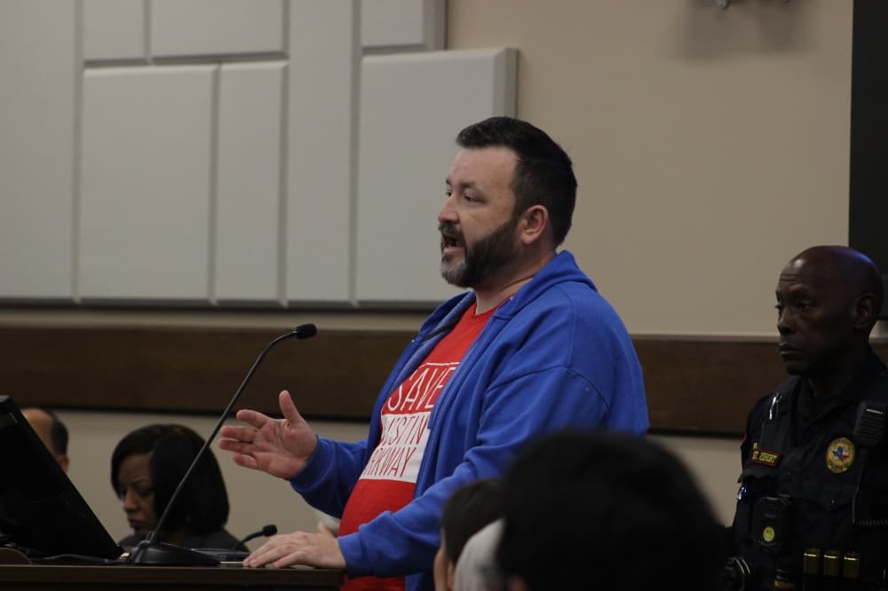 Several speakers wore red t-shirts with 'Save Austin Parkway.' (Aubrey Howell/Community Impact)