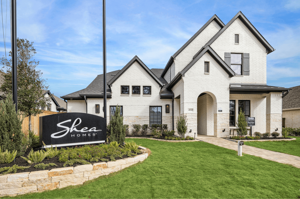 Luxury two-story home exterior at Wildtree in Magnolia by Shea Homes, featuring large windows and nature-filled surroundings