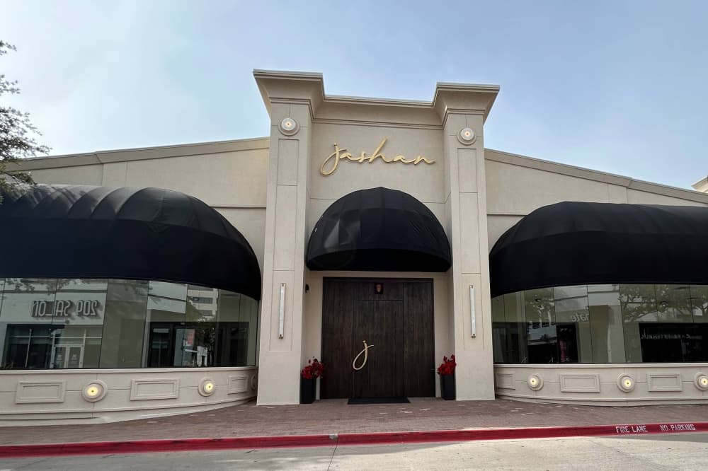 Exterior of a building featuring canopy-topped windows and Jashan signage. 