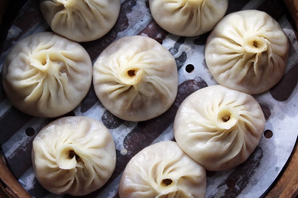 Steamed Chinese buns in a bamboo warming container. 