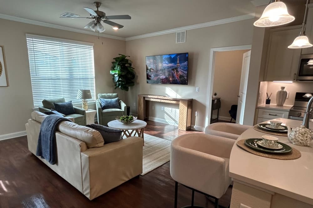 Living area featuring sofa and pendant lighting hanging over a marble counter top bar. 