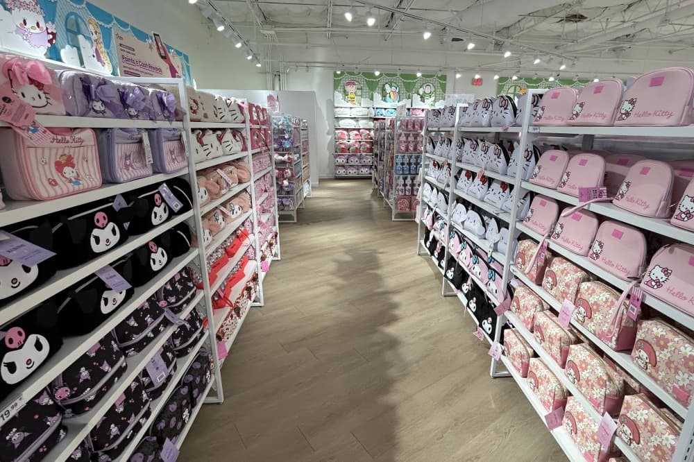 Aisle in a store with a variety of hello kitty bags displayed on shelves. 