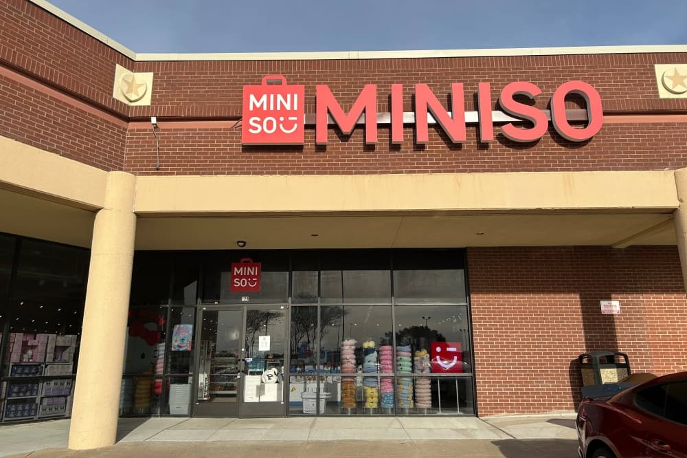 Exterior of a retail center featuring Miniso signage. 
