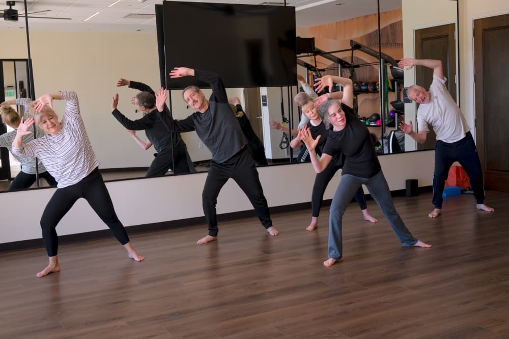 A lively movement class in action— students embrace the joy of embodied exercise, blending yoga with creative expression.