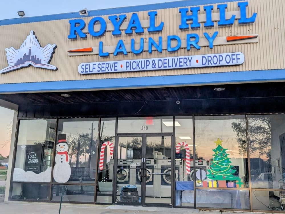 Modern Royal Hill Laundry laundromat interior in Jersey Village Houston featuring high-speed commercial washing machines, bright seating areas, and a clean family-friendly environment designed for convenient laundry day services.