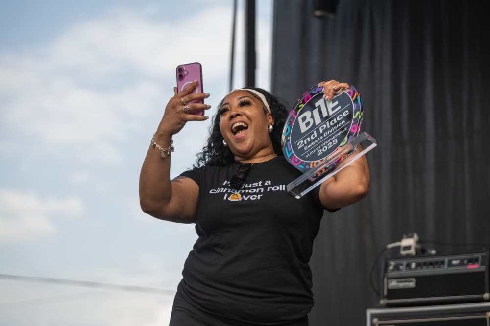 Person posing with winning bite passport award