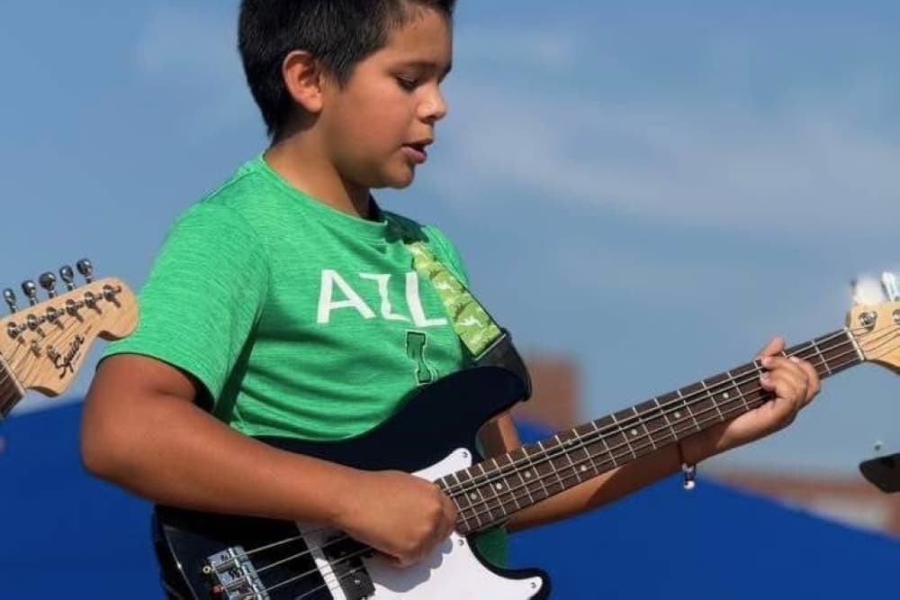 Male pre-teen playing electric guitar. 