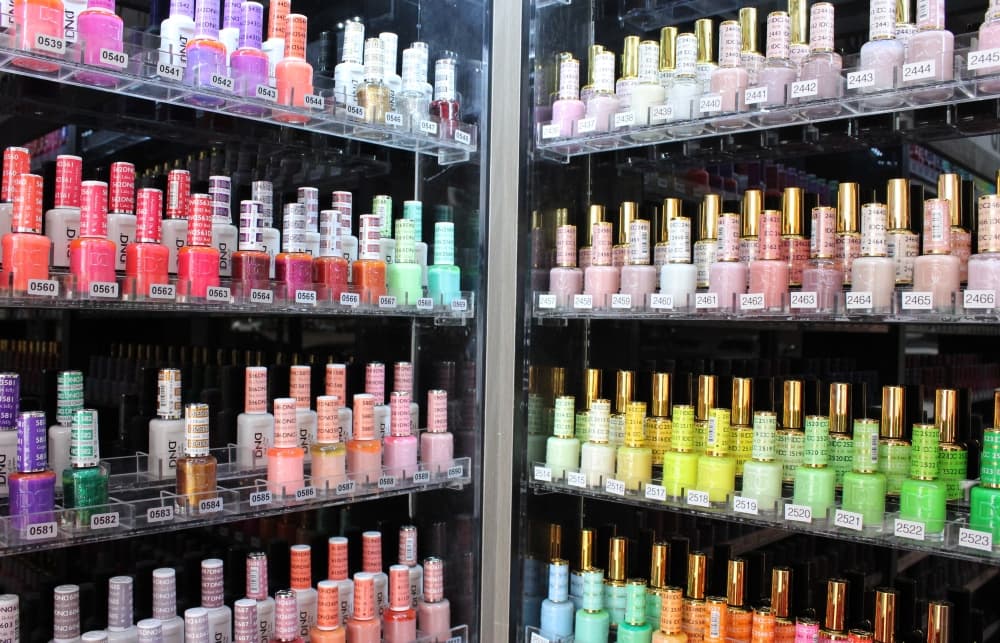 A variety of nail polish bottles displayed on shelves. 
