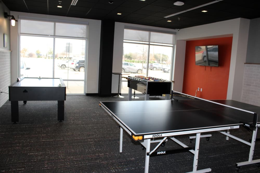 Ping pong table and foosball table in a game room. 