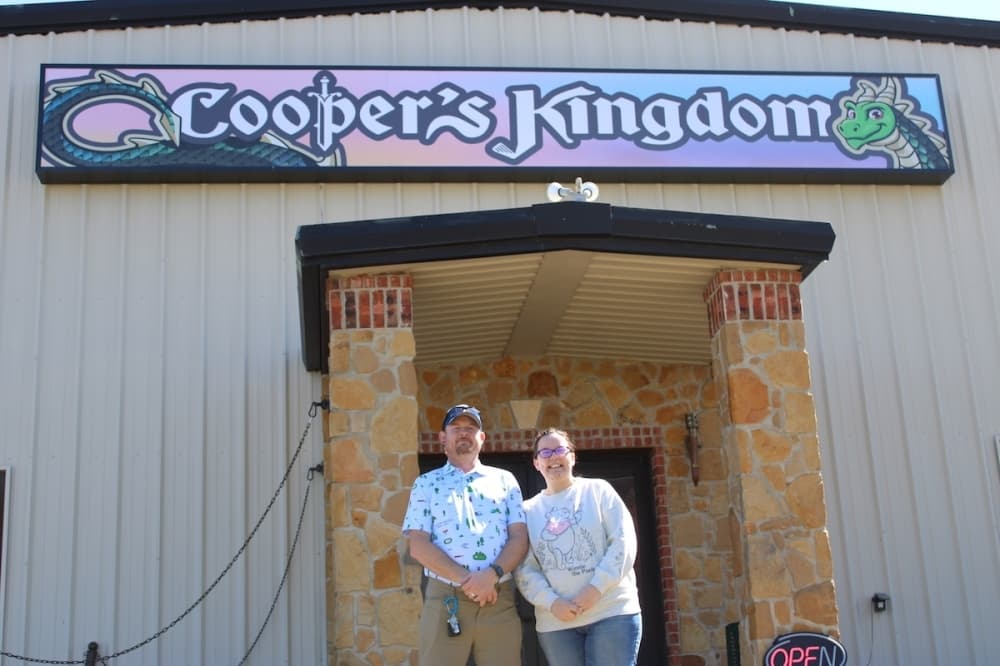 Exterior of Cooper's Kingdom with the two owners standing outside.