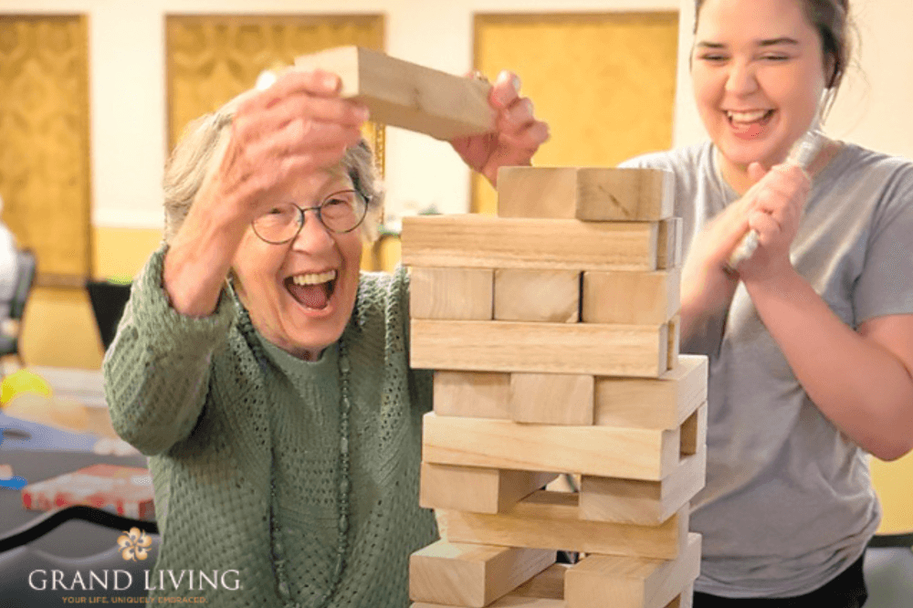 Resident playing Jenga by staff member