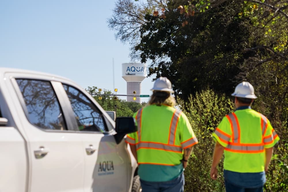 Aqua Water Supply employees looking at water tower