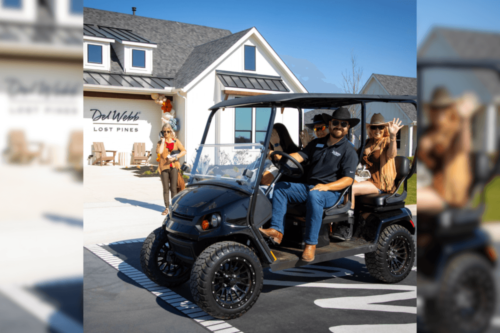 people with cowboy hats on golf cart at Lost Pines grand opening event