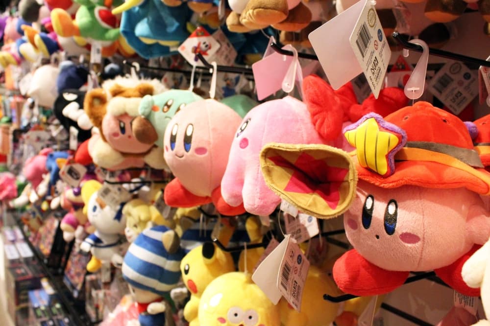 Videogame-themed plushies displayed on a wall. 