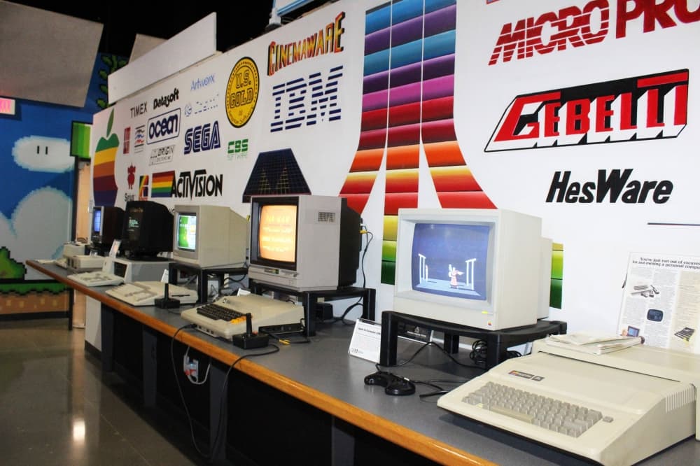 Computers from different decades displaying videogames. 