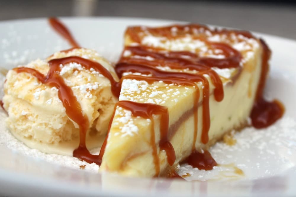 Slice of pie a la mode featuring caramel drizzle. 