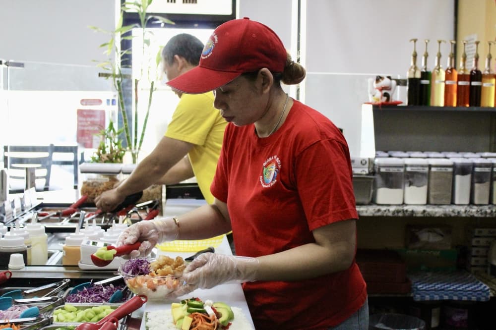 Co-owner Ellie Sou prepares a poke bowl. (Jovanna Aguilar/Community Impact)