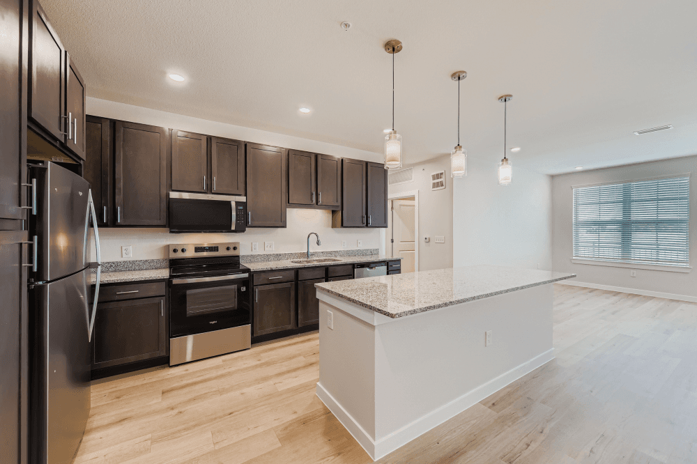 Spacious one-, two-, three-, and four-bedroom apartment interiors with granite countertops, vinyl tile flooring, and Energy Star appliances.