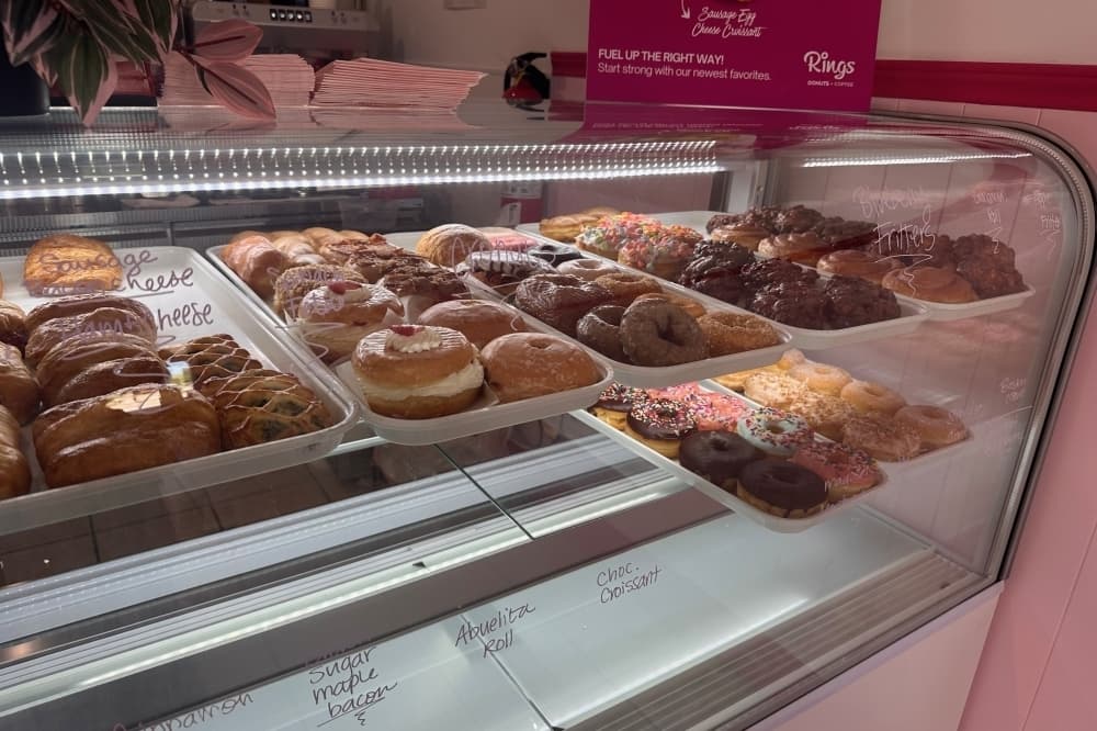 Bakers case featuring a variety of donuts on trays. 