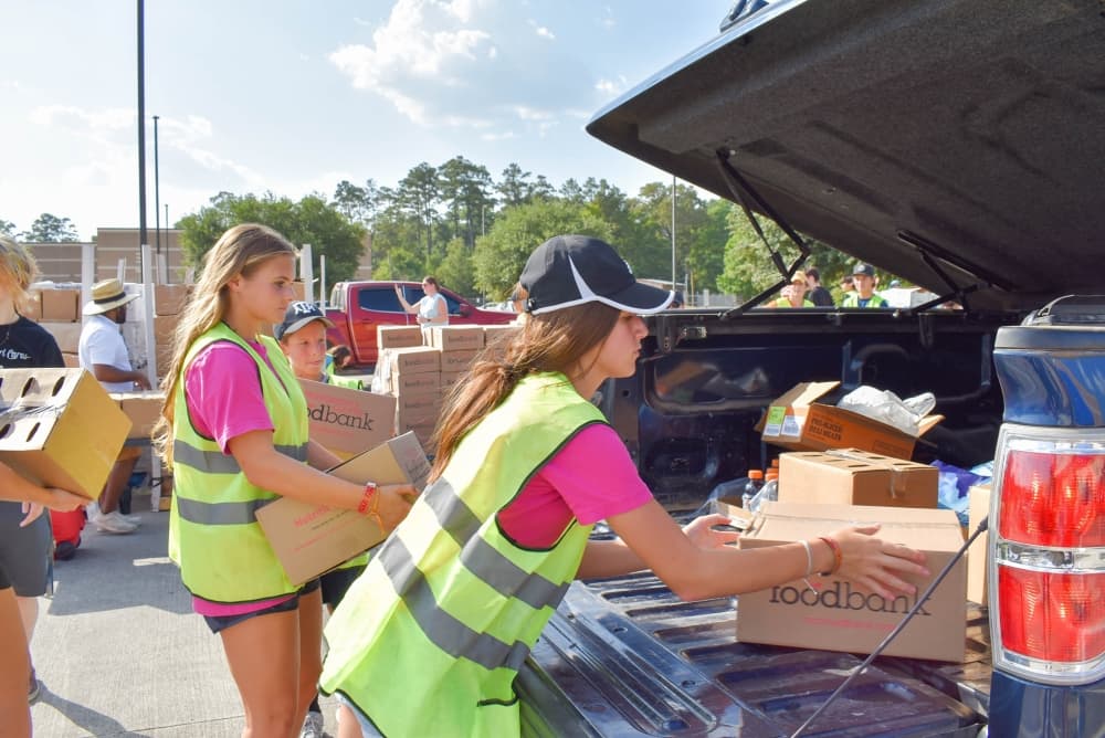 people load groceries into a car