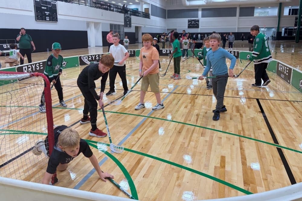 kids practicing hockey in a gym