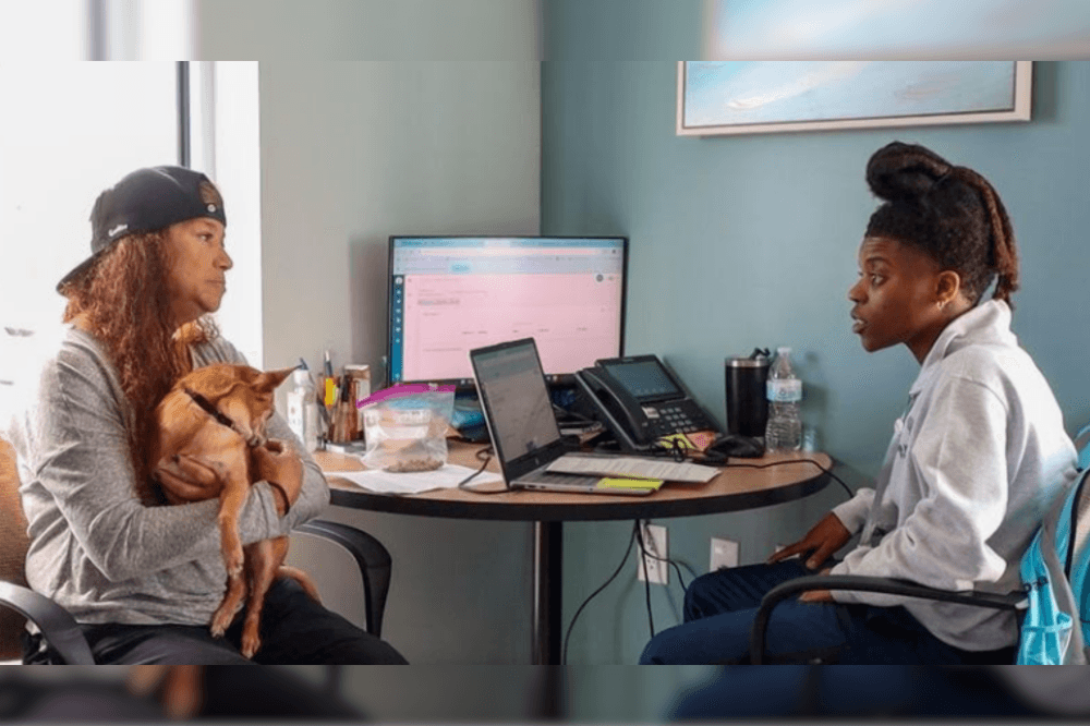 employee speaking with client with her dog