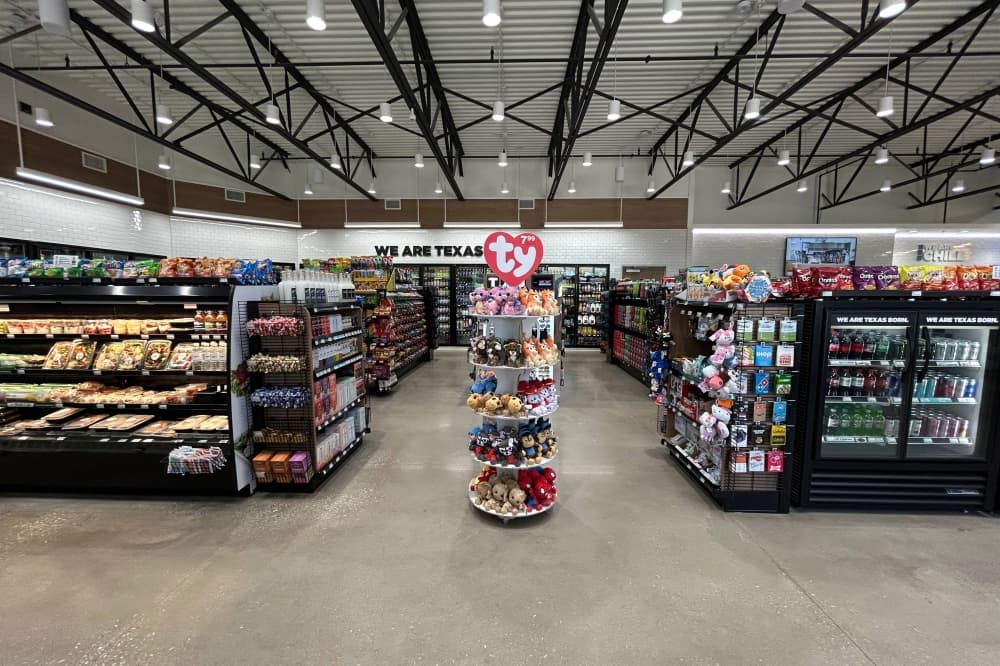 interior of a convenience store featuring stuffed animals and pre-packaged food items. 