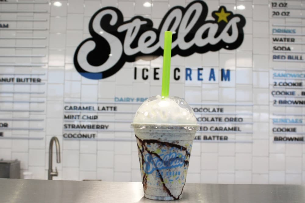 A milkshake in a clear cup featuring Stella's Ice Cream branding. 