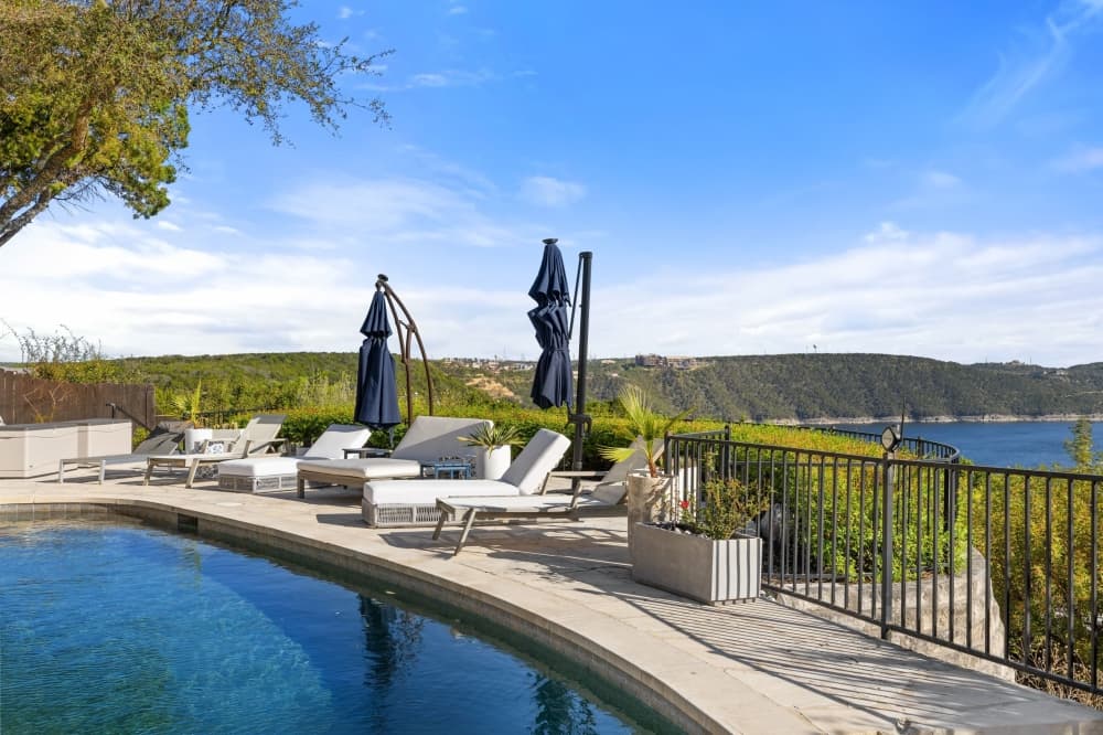 pool with chairs and umbrellas overlooking the lake