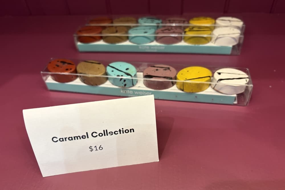 The caramel collection from Kate Weiser Chocolate sits inside a display shelf.